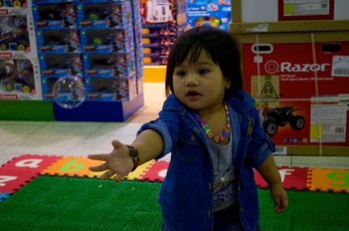 A child reaches for a bubble outside a toy store in Landmark Mall.